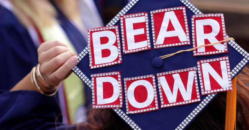 Arizona online student graduating and throwing grad cap with "bear down" written on it
